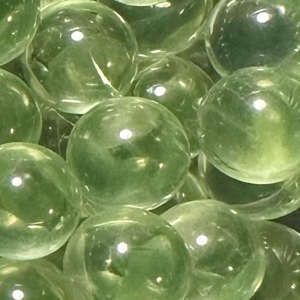 Peridot 10mm: kleine knikker van doorschijnend lichtgroen glas