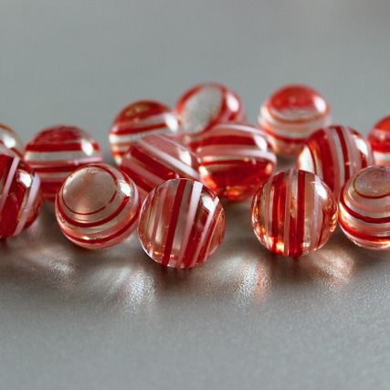 Zuurstok 16mm: knikker van helder roze glas met rode en witte strepen